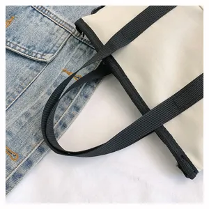 Sac cabas en toile vue de détail, sac à épaule beige décontracté avec anses noires.