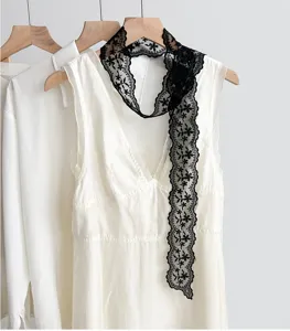 Vue détaillée du long foulard fin en dentelle noire, élégante décoration de cou et de cheveux.