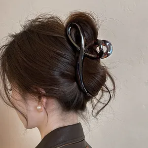 Detailansicht einer stilvollen schokombraunen Haarklammer im Dutt, elegantes Design.