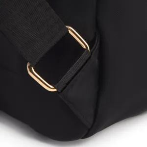 Detailopname van een stijlvolle zwarte oxford stoffen rugzakriem met gouden metalen gesp.