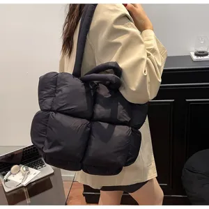 Gedetailleerd overzicht van zwarte gewatteerde tas, zacht gevoerd ruitontwerp voor mode.