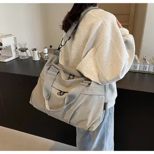 Λεπτομερής όψη της μεγάλης τσάντας ταξιδίου με ανθεκτικά χερούλια και ρυθμιζόμενο λουρί.