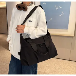 Λεπτομερής λήψη της μαύρης casual τσάντας ταξιδιού που δείχνει ανθεκτικό ύφασμα και λαβές.
