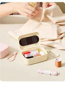 Boîte à couture mini portable avec porte-aiguille aimanté, fils colorés et ruban à mesurer.