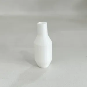 Close-up detail view of white plastic siphon accessory valve part with faceted design