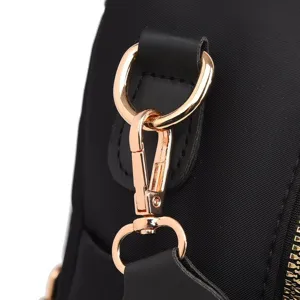 Gedetailleerd overzicht haak van zwarte rugzakriem en roségouden hardware, chic.