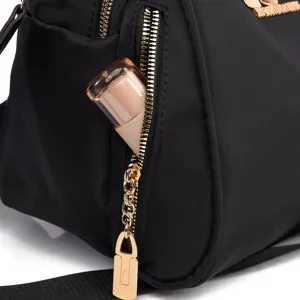 Detail van zwarte oxford stoffen schelp rugzak met gouden rits en handig voorvak.