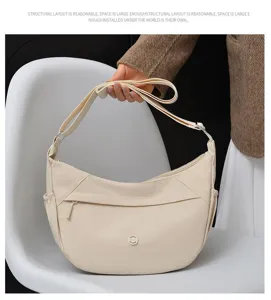Detailed view of the minimalist beige crescent crossbody bag, showcasing its large capacity.