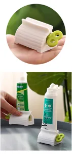 Vue détaillée du presse-dentifrice manuel blanc avec poignée verte, clip pratique rouleau.