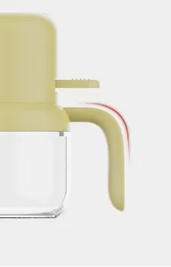 Kitchen oil sprayer detail shot, heat-resistant glass bottle with ergonomic press handle for cooking.