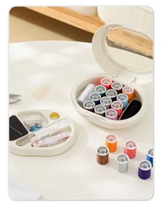 Kit de couture magnétique portable avec bobines de fil colorées, ciseaux et mètre ruban.