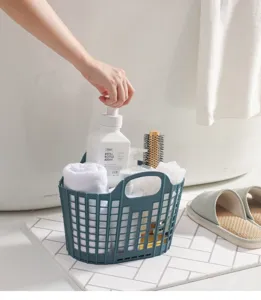 Vue détail de la corbeille à linge pliante en plastique dans la salle de bain avec accessoires.