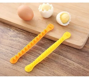 Detailed view of yellow plastic egg cutter tool showing zig-zag shaping for creative salads.