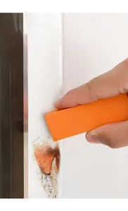 Detailopname toont oranje reinigingsgum die hardnekkige vlekken van het oppervlak verwijdert.