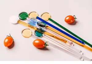 Detailed view of colorful heat-resistant glass stirring rods for coffee, juice, and desserts.