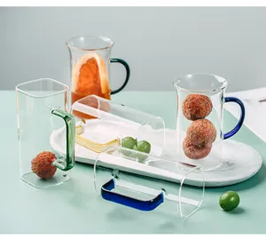 Clear glass coffee mug with colorful handle detail, aesthetic table setup for morning tea.