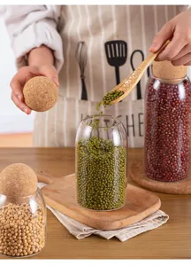 Glass storage jar detail showcasing cork ball lid and filled with organic mung beans.