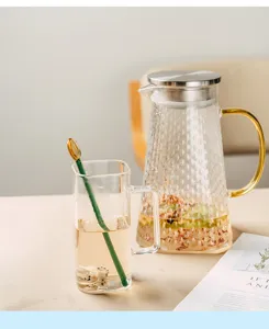 Heat-resistant glass pitcher with hammered texture and golden handle detail for home kitchen use.