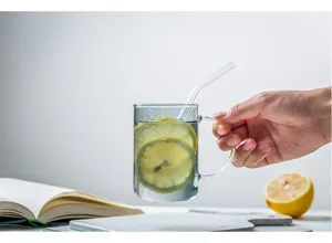 Vista dettagliata di tazza in vetro trasparente con manico e limone fresco dentro.