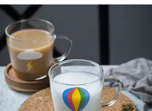 Gros plan détail de tasse à café lait en verre transparent avec joli motif ballon, résistant.