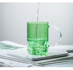 Vista di dettaglio della tazza di vetro verde con design trasparente resistente al calore.
