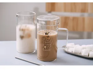 Gros plan d'une tasse à café en verre transparent avec couvercle et paille, design élégant.