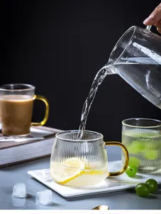 Gedetailleerd overzicht van de Japanse gegroefde glazen waterbeker met gouden handvat voor thee.