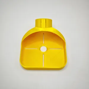 Vista dettagliata del collettore di polvere per trapano stampato in 3D giallo con fori chiari.