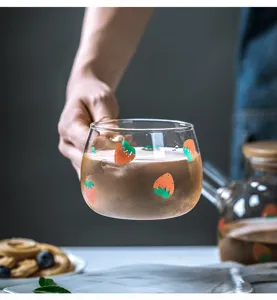 Dettaglio di tazza in vetro con fragole, ideale per caffè freddo, succhi e bevande fresche.