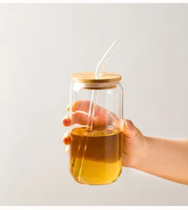 Glass cup with bamboo lid and straw, clear soda can shape for daily drinking, close-up view.