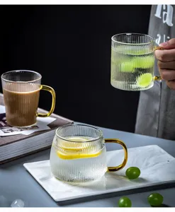 Japanse hittebestendige geribbelde glazen waterbeker met gouden handvat voor thee.