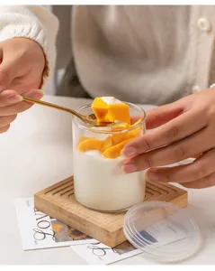 Tasse à pudding en verre transparent avec couvercle sous-verre en bois vue détail.