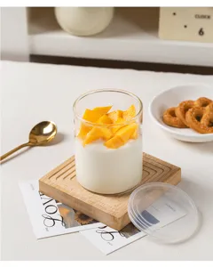 Vue détaillée du pot à dessert en verre transparent avec un sous-verre en bois et couvercle.