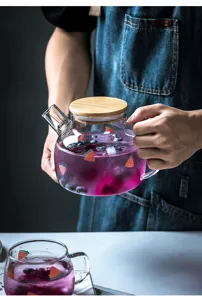 Teiera in vetro trasparente con coperchio in legno e stampa anguria, ideale per tisane.