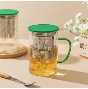 Detailed view of glass tea infuser cup with floral pattern and stainless steel filter.