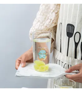 Bonito vaso de vidrio con diseño de perrito azul y agua, vista detallada en cocina.
