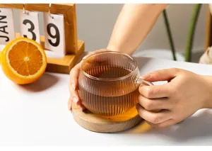 Ribbed glass coffee cup with wooden coaster, transparent glassware for hot milk and tea.
