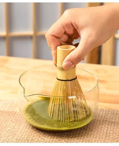 Bamboo matcha whisk and clear glass bowl set for traditional Japanese green tea ceremony preparation