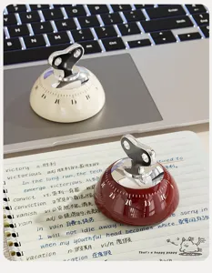 Close-up detail view of the mechanical kitchen timer in red and beige, perfect for baking.