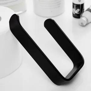 Black metal over cabinet paper towel holder detail shot for kitchen and bathroom paper storage.