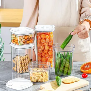 Set van doorzichtige plastic voedselopslagbakjes met witte deksels voor keukenorganisatie.