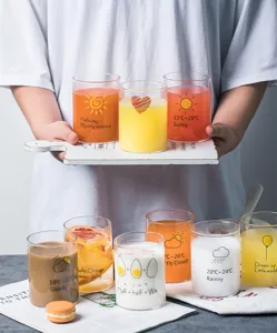 Detailed shot of creative glass cup with cute weather patterns and English text for drinks.