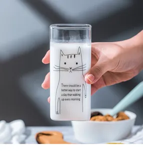 Close-up of a cute square glass milk cup with lovely cat illustration and stylish text.