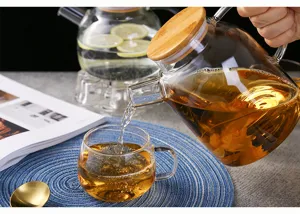 High borosilicate glass teapot with wooden lid and glass cup for loose leaf tea and cold water.