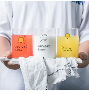 Detailed shot of clear glass cups with cute weather prints and text, holding cold drinks.