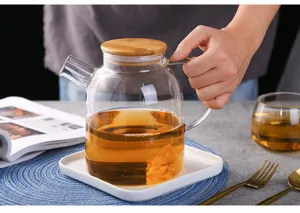 Clear glass teapot detail shot featuring a natural wooden lid and heat-resistant body.