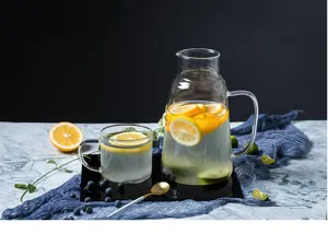 Ensemble de pichet et tasse en verre avec citrons frais et myrtilles pour cuisine et table.