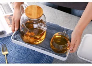High borosilicate glass teapot detail shot featuring bamboo lid and heat-resistant kettle design.