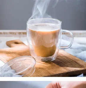 Detailansicht der klaren doppelwandigen Glaskaffeetasse mit Deckel und Griff auf Holzbrett.