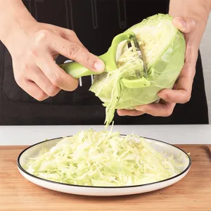 Green cabbage shredder and vegetable peeler with stainless steel dual blade for kitchen.